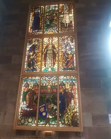 Stained glass window in St Peter's church featuring images of nurses and religious figures