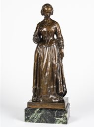 Miniature bronze statuette (maquette) of Nightingale based on the Walker statue in London. Nightingale is standing with her head turned demurely to the left and towards the ground.